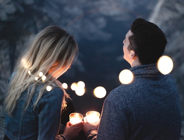 blonde Frau und braunharriger Manntrinken etwas gemeinsam bei romantischem licht